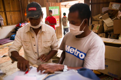 Volunteer Awi Along from Kampung Depak issues a receipt for released items at the food collection center in Kampung Parik. Photo courtesy of JOAS 