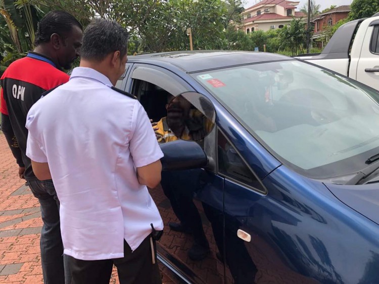 Challenged - identified police officers hovering in a car with false plates outside the home of an anti-corruption campaigner who met with Lim on Monday
